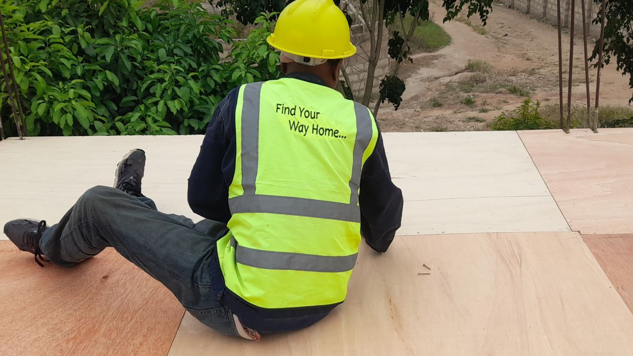 Worker seated on plywood decking